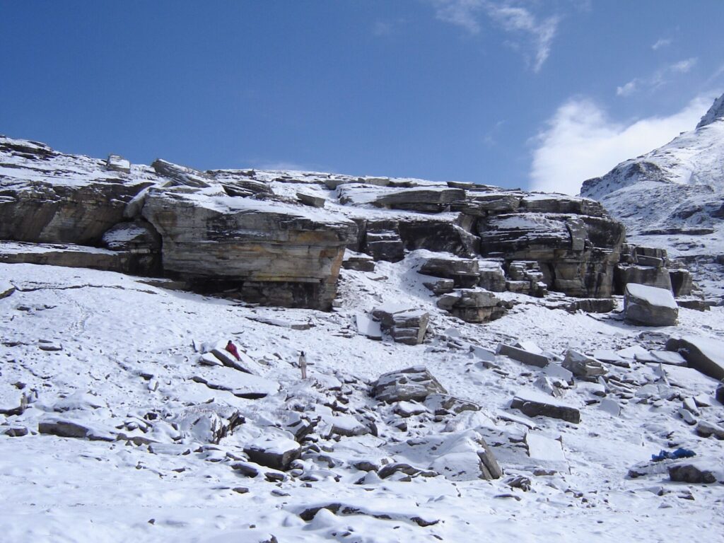 A serene snow-covered landscape at Rohtang Pass, captured in 2014, featuring rugged rock formations and pristine white snow under a clear blue sky.